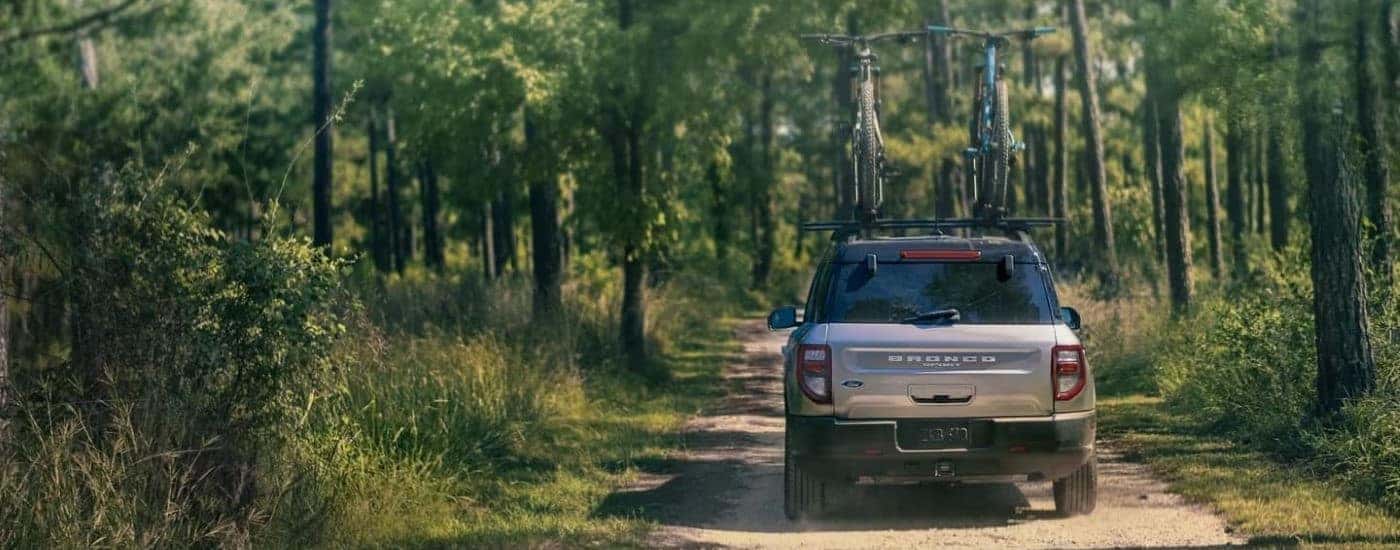 Grey 2023 Ford Bronco Sport driving down a trail with bikes on the roof