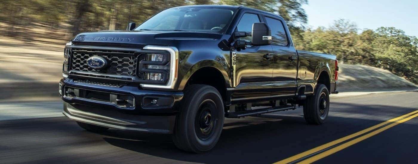 Black 2023 Ford F-250 STX driving to a Used Car Dealership near Latham