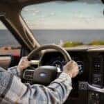 A person driving a 2025 Ford F-150 Lariat.