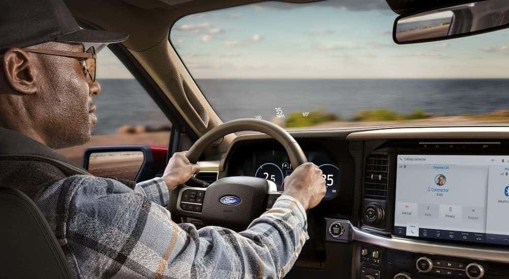 A person driving a 2025 Ford F-150 Lariat.