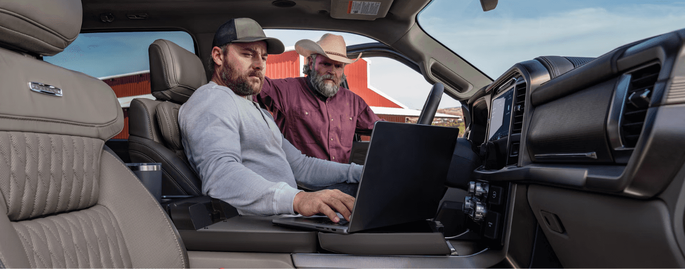 Two people using the interior office space feature on the 2025 Ford F-150 Lariat