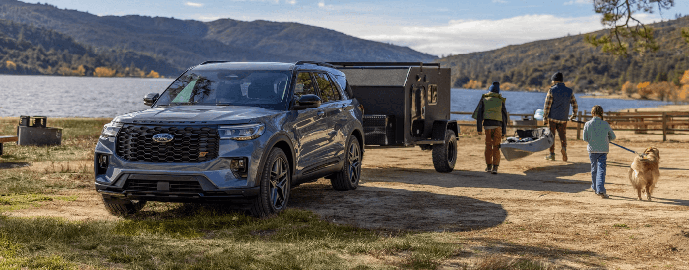 Grey 2026 Ford Explorer towing a camper parked off-road