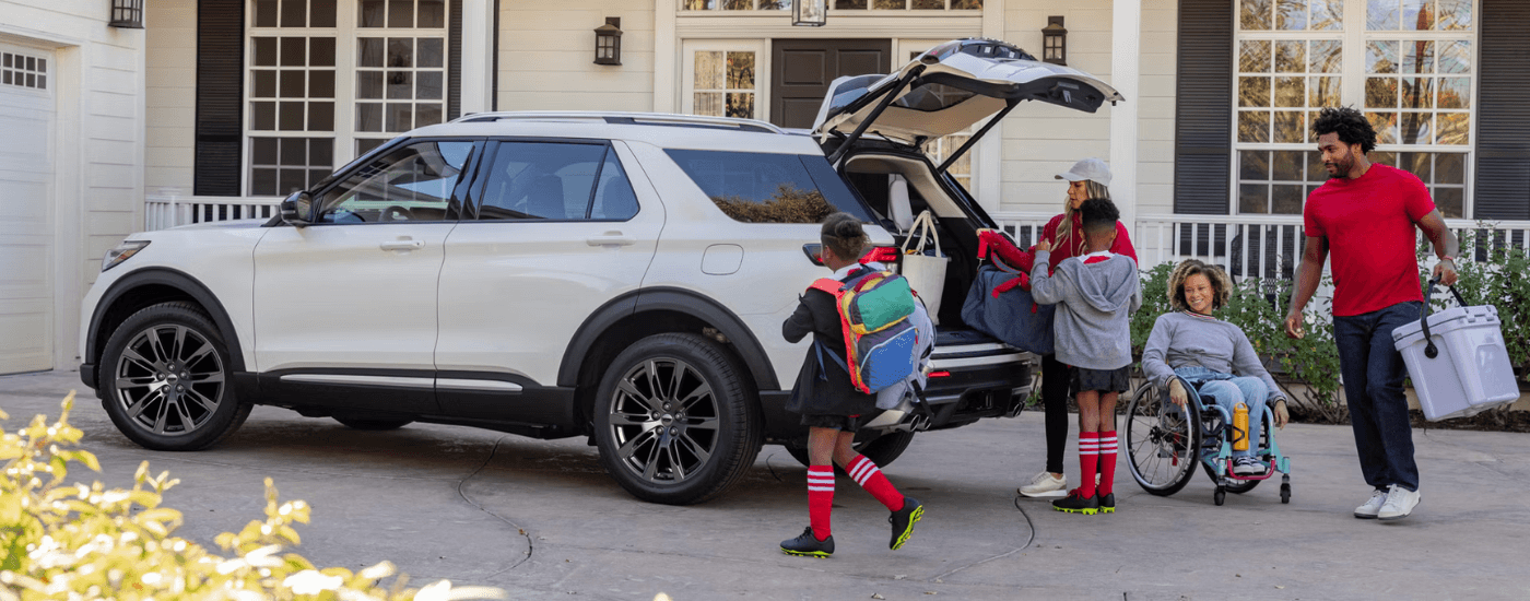 A family piles their belongings into the trunk of a white 2026 Ford Explorer