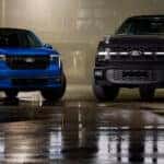 A black and a blue Ford F-150 parked beside eachother.