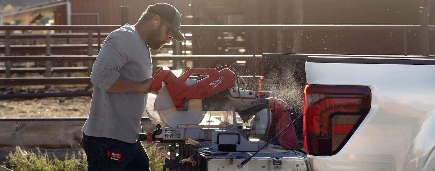 A person using a saw on the tailgate of a 2025 Ford F-150.