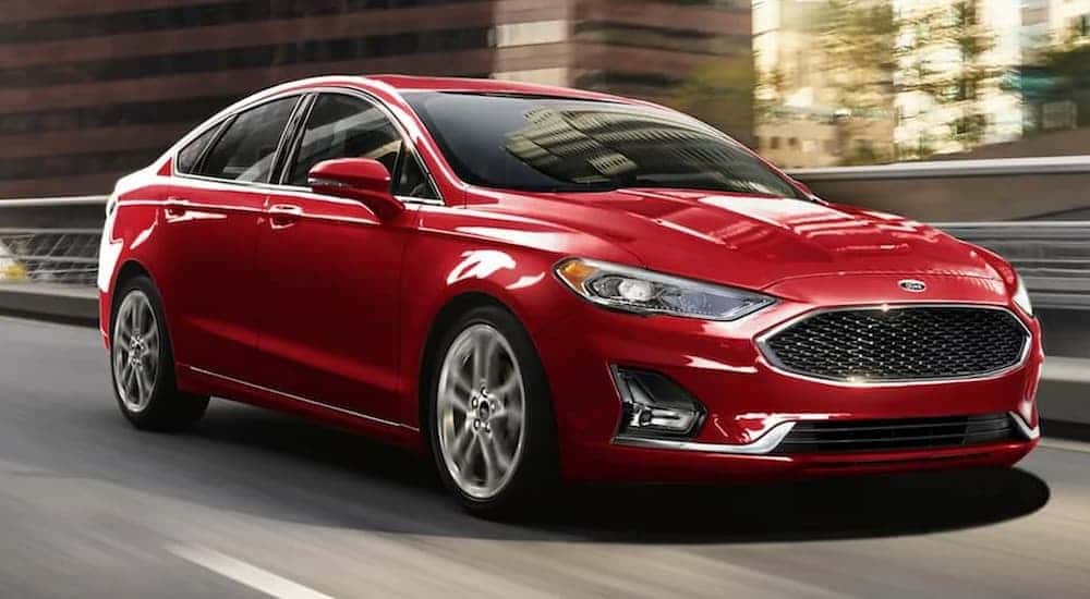 Red 2020 Ford Fusion driving on a city street