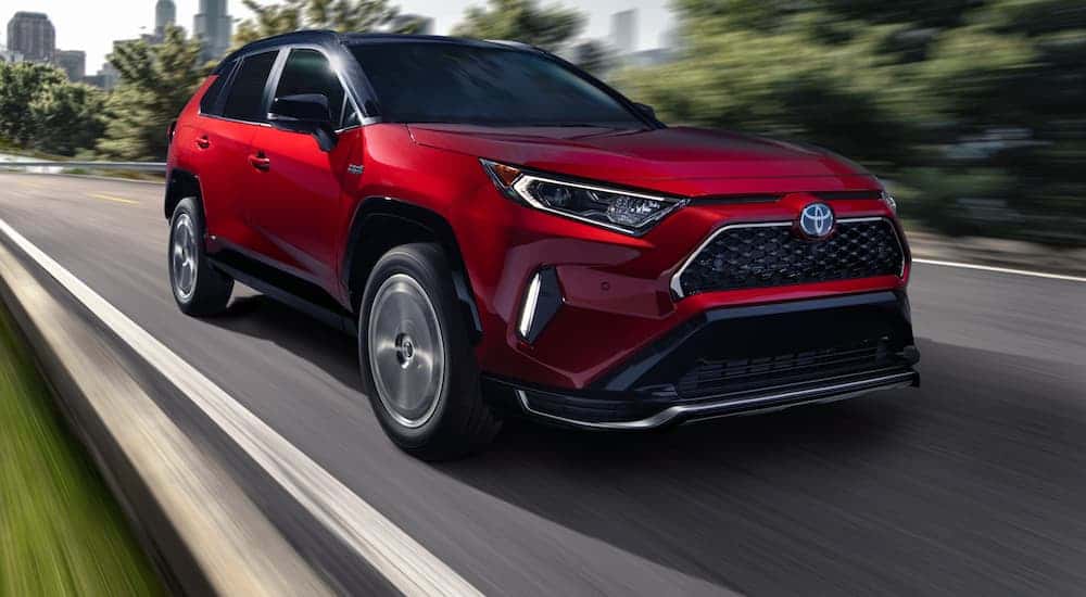 Red 2021 Toyota RAV4 driving on an open road