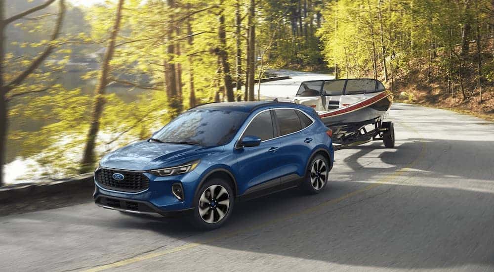 Blue 2023 Ford Escape towing a boat