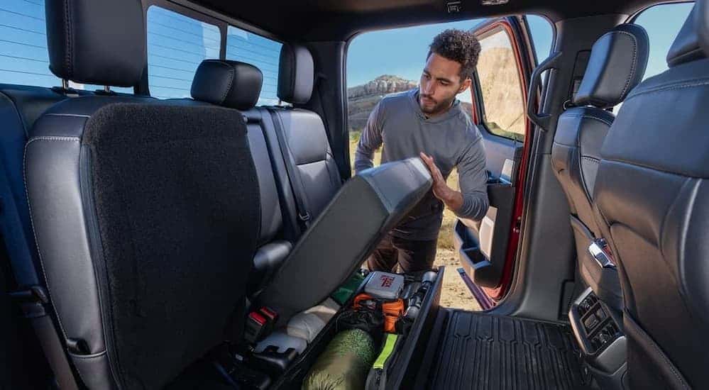 A person utilizing the under-seat storage in a 2026 Ford F-150.
