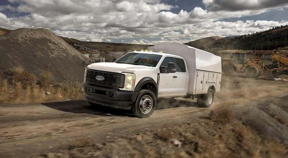 A white 2026 Ford F-450 driving on a dirt road.