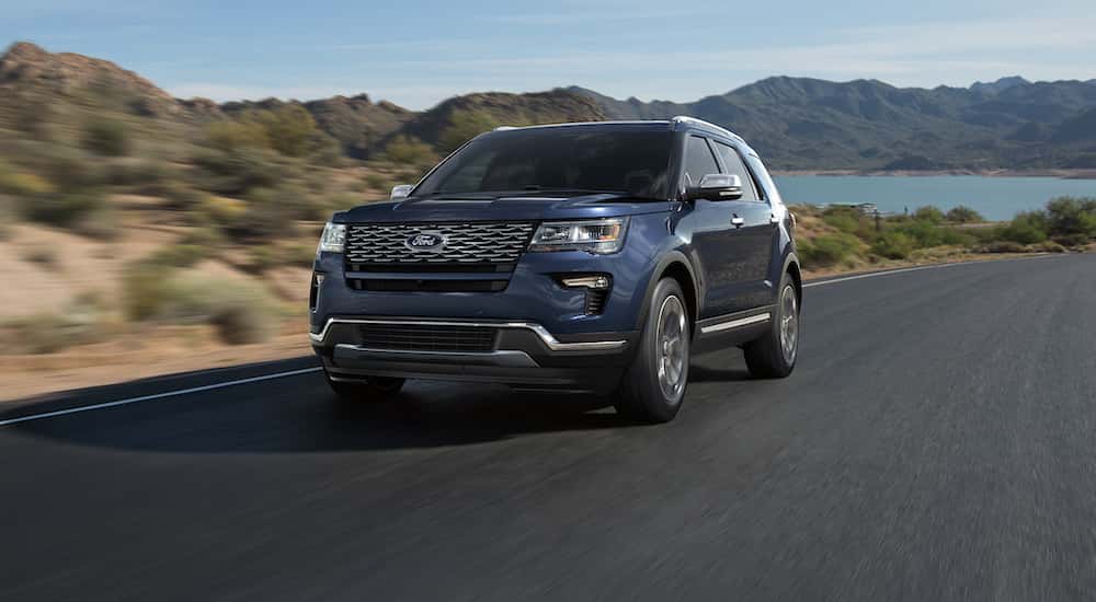 Black 2018 Ford Explorer driving down a road from a used car dealer near Ballston Spa.