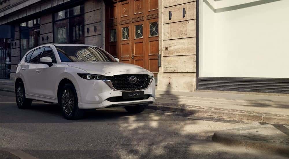 White 2022 Mazda CX-5 parked by a building.