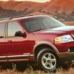A red 2002 Ford Explorer parked off-road.
