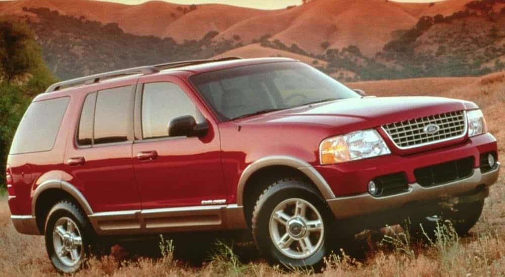 A red 2002 Ford Explorer parked off-road.
