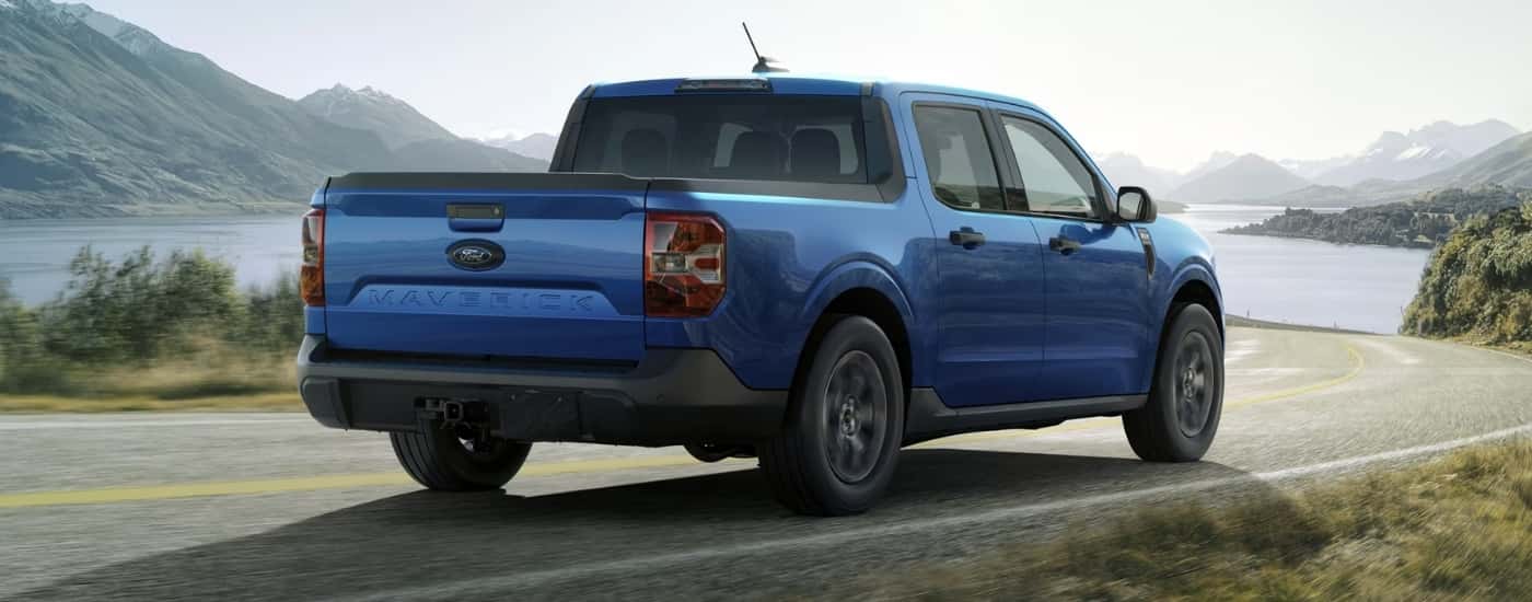 A blue 2025 Ford Maverick from behind after leaving a Ford service center.