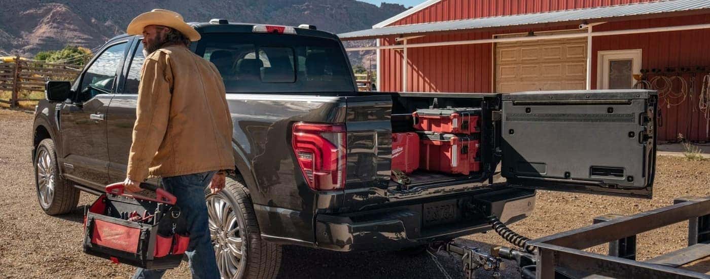 A person walking near the bed of a gray 2026 Ford F-150.