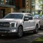 A white 2026 Ford F-150 towing a boat.