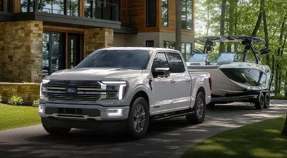 A white 2026 Ford F-150 towing a boat.