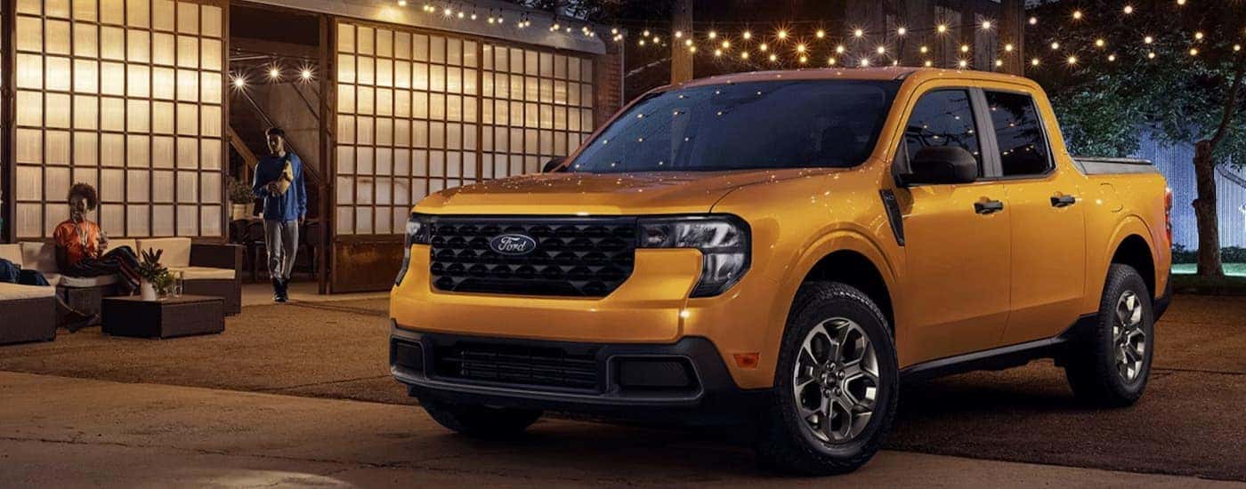 An orange 2026 Ford Maverick parked outside a building