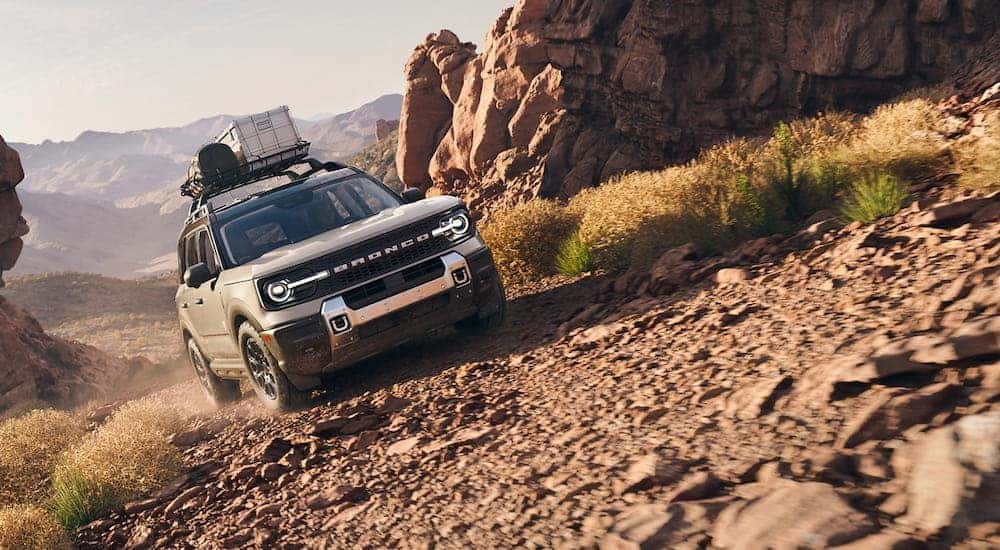 White 2026 Ford Bronco Sport driving off-road up a hill.