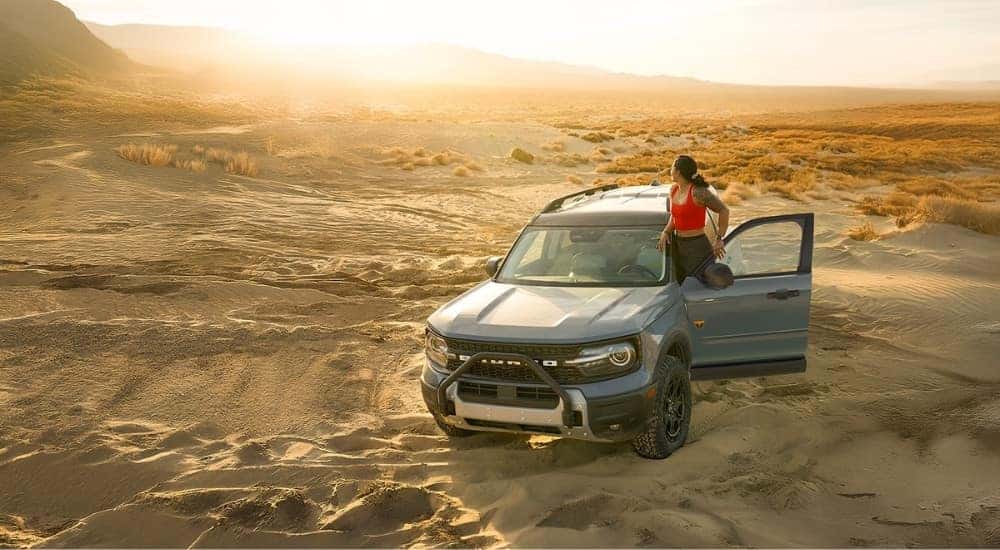 A person standing on the door of their silver 2026 Ford Bronco Sport Badlands