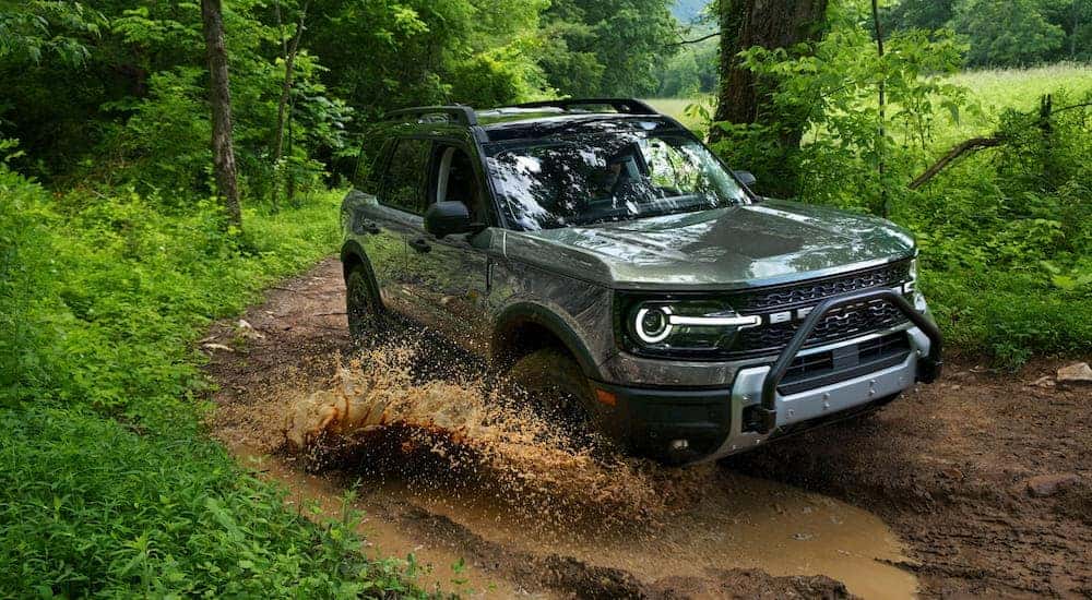 Silver 2026 Ford Bronco Sport driving through a mud puddle.