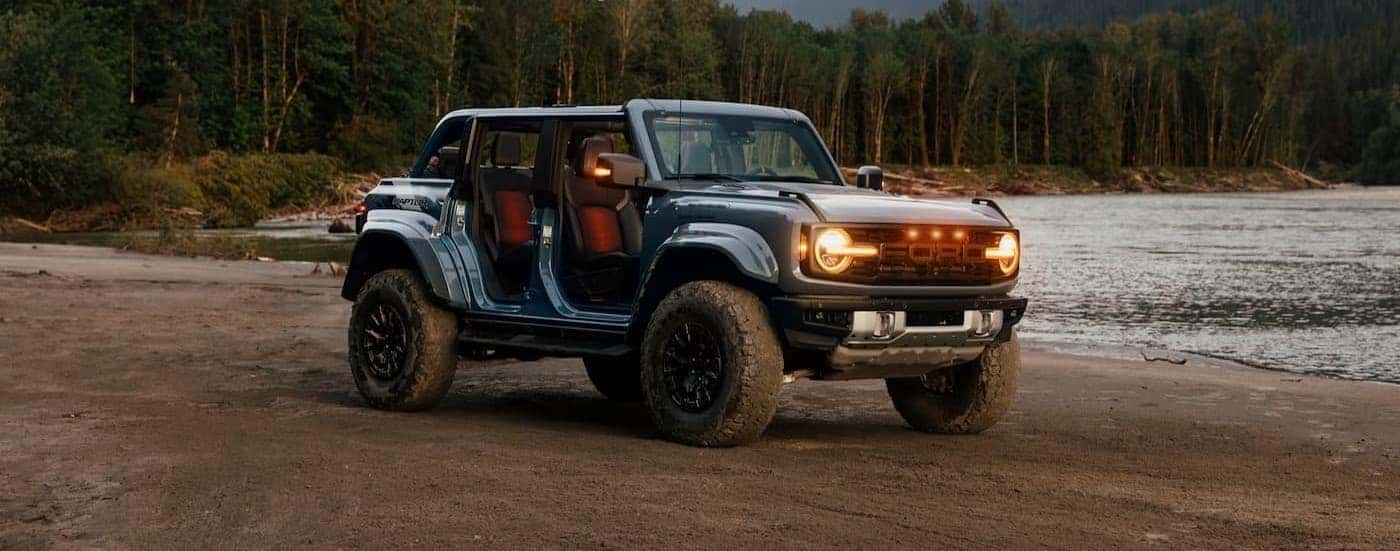 A blue 2026 Ford Bronco Raptor parked near water.