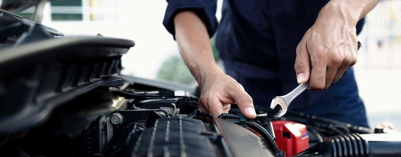 Mechanic using a wrench on vehicle's engine