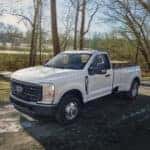 White 2023 Ford F-350 parked on a wooded trail