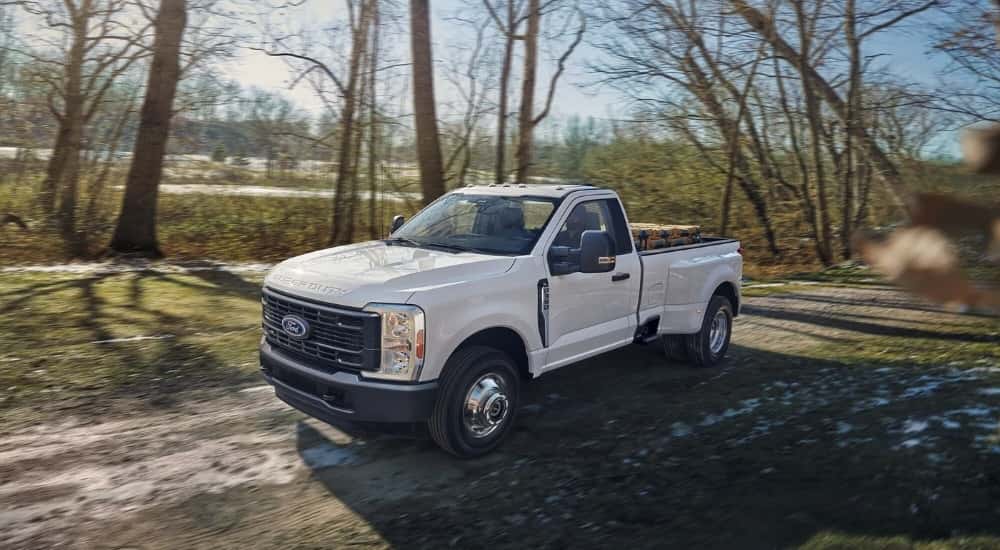 White 2023 Ford F-350 parked on a wooded trail