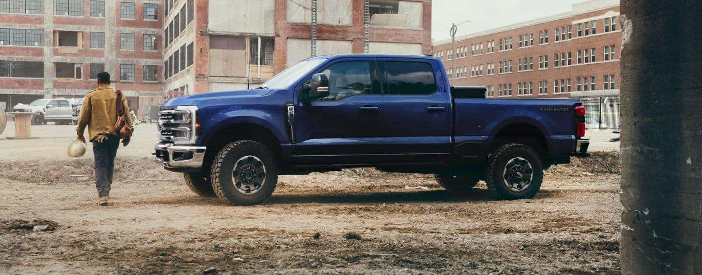 Blue 2026 Ford Super Duty F-250 parked on a construction site with a man walking away