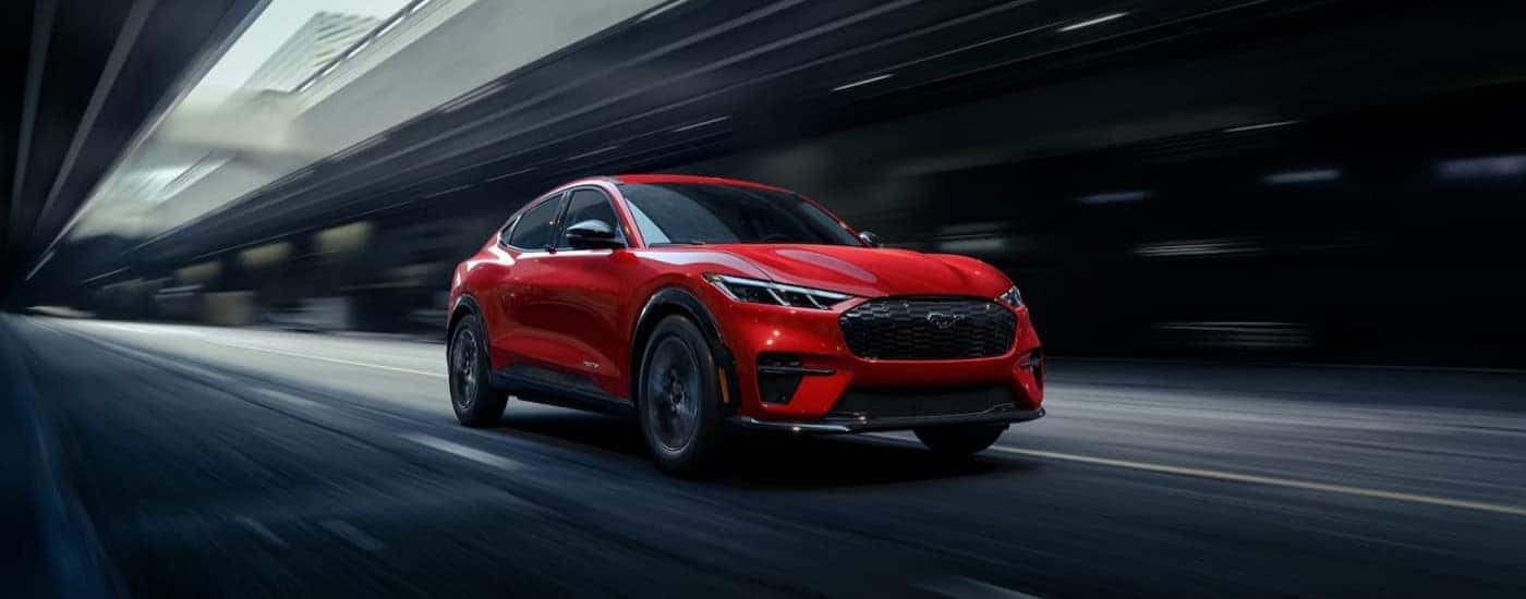 A red 2026 Ford Mustang Mach-E driving in a tunnel.
