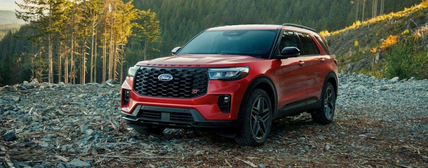 Red 2026 Ford Explorer parked on a rocky flat area in the woods