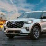 Silver 2026 Ford Explorer parked on a pier with a Ferris wheel in the background