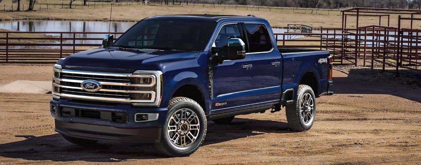 Blue 2026 Ford Super Duty F-350 Platinum Plus parked on a farm