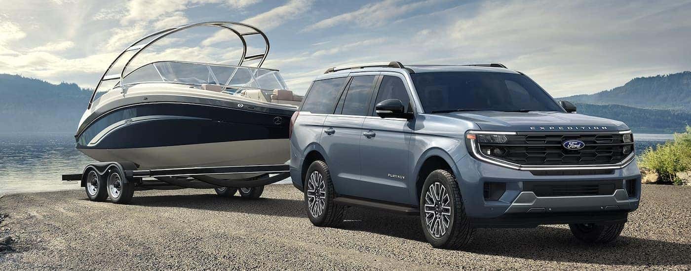A blue 2026 Ford Expedition towing a boat