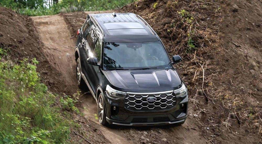 A black 2025 Ford Explorer Active driving down a dirt hill.