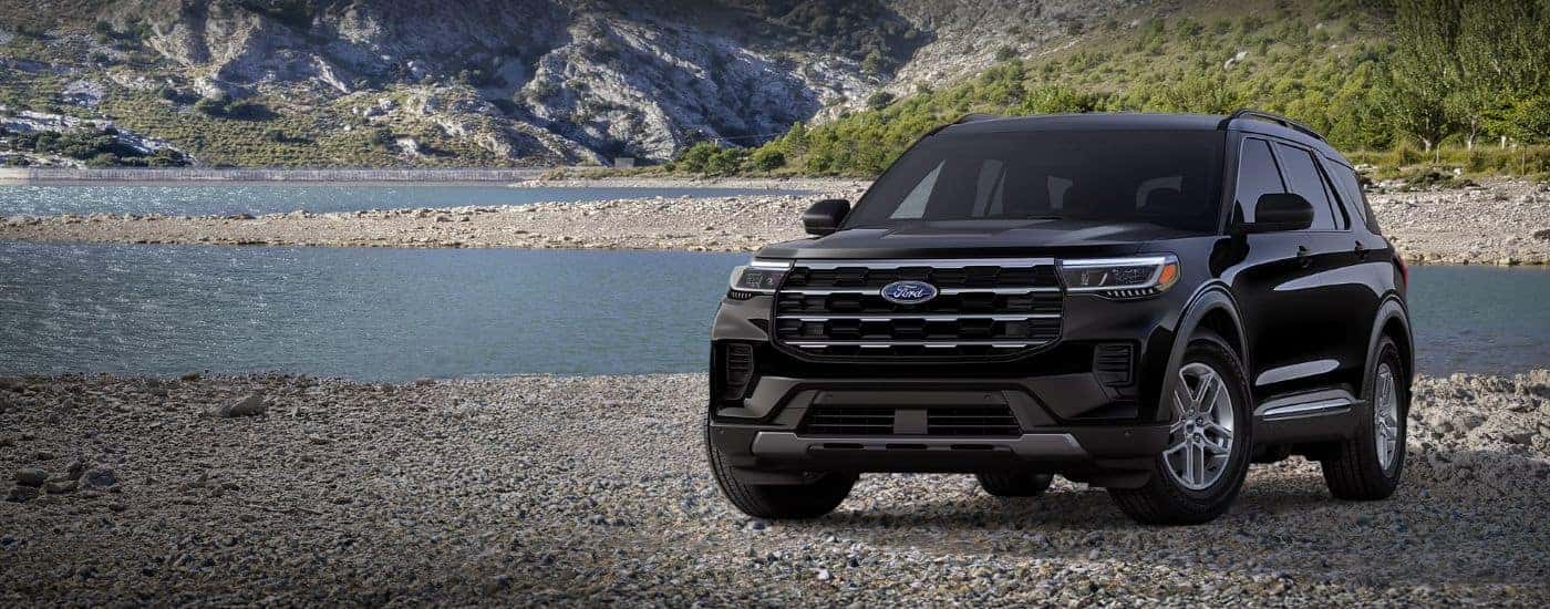 Black 2026 Ford Explorer Active parked on a rocky beach.