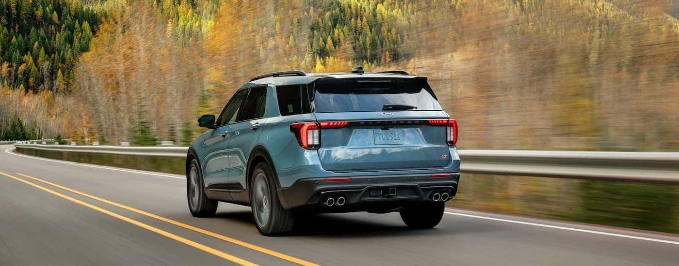 A blue 2026 Ford Explorer driving down a rural road