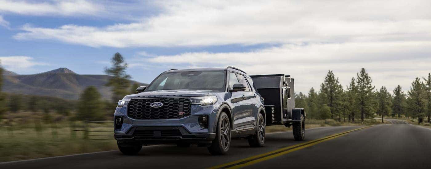 A blue 2026 Ford Explorer towing a trailer