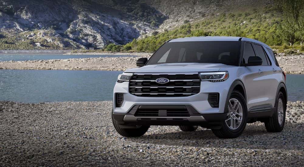 Silver 2026 Ford Explorer Active 100A parked on a rocky beach.
