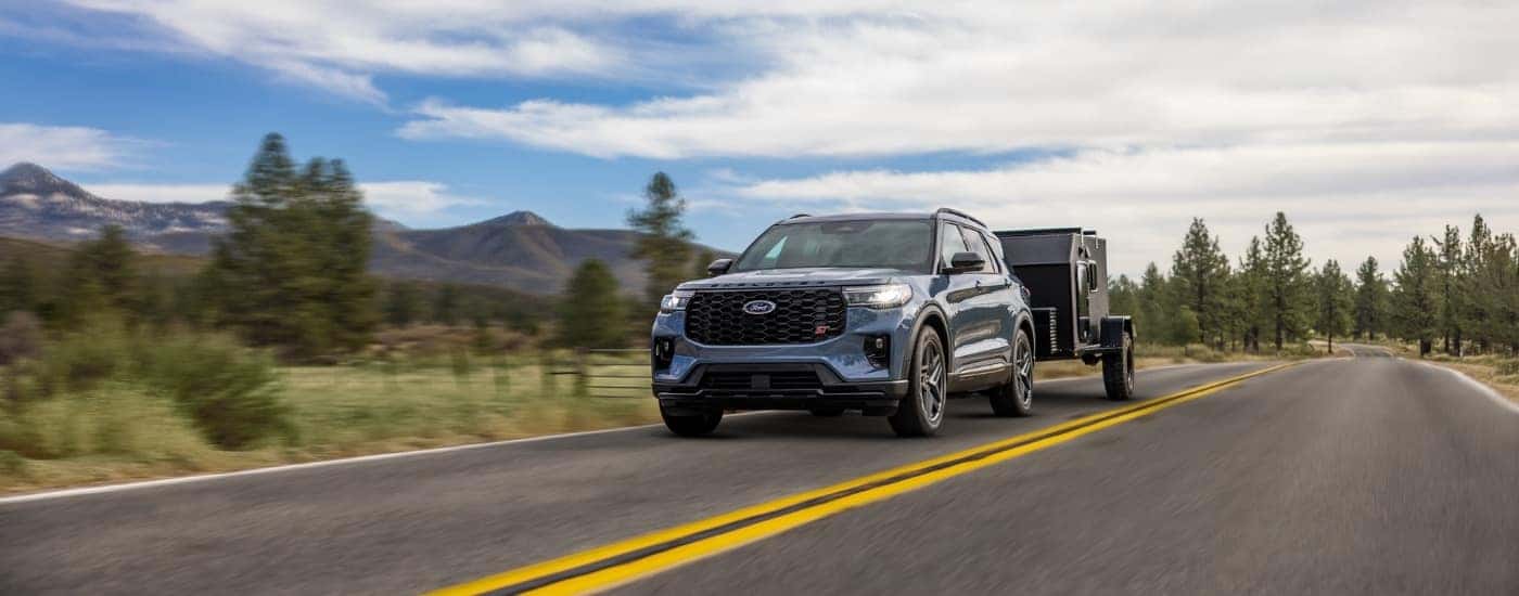 A blue 2026 Ford Explorer ST towing a trailer