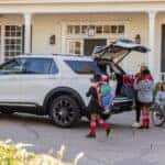 White 2026 Ford Explorer with a family loading luggage into the cargo area