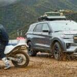A gray 2026 Ford Explorer parked by people dirtbiking.