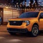 A yellow 2026 Ford Maverick is parked under string lights.