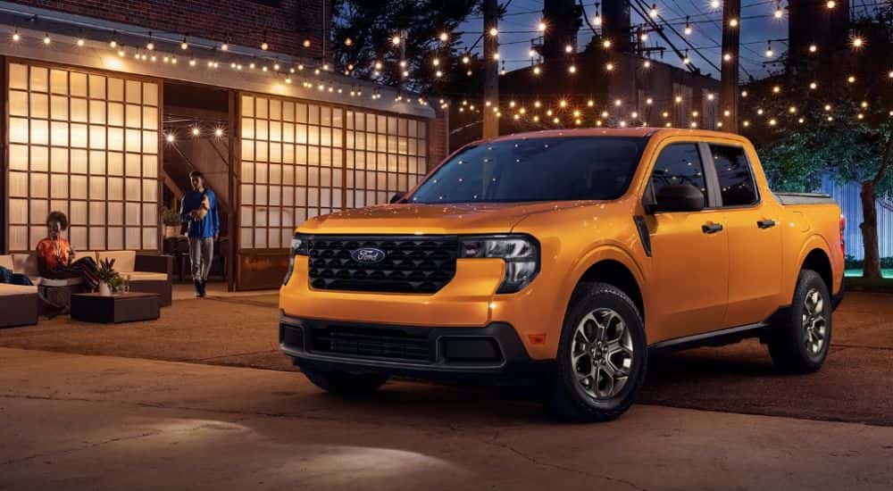 A yellow 2026 Ford Maverick is parked under string lights.