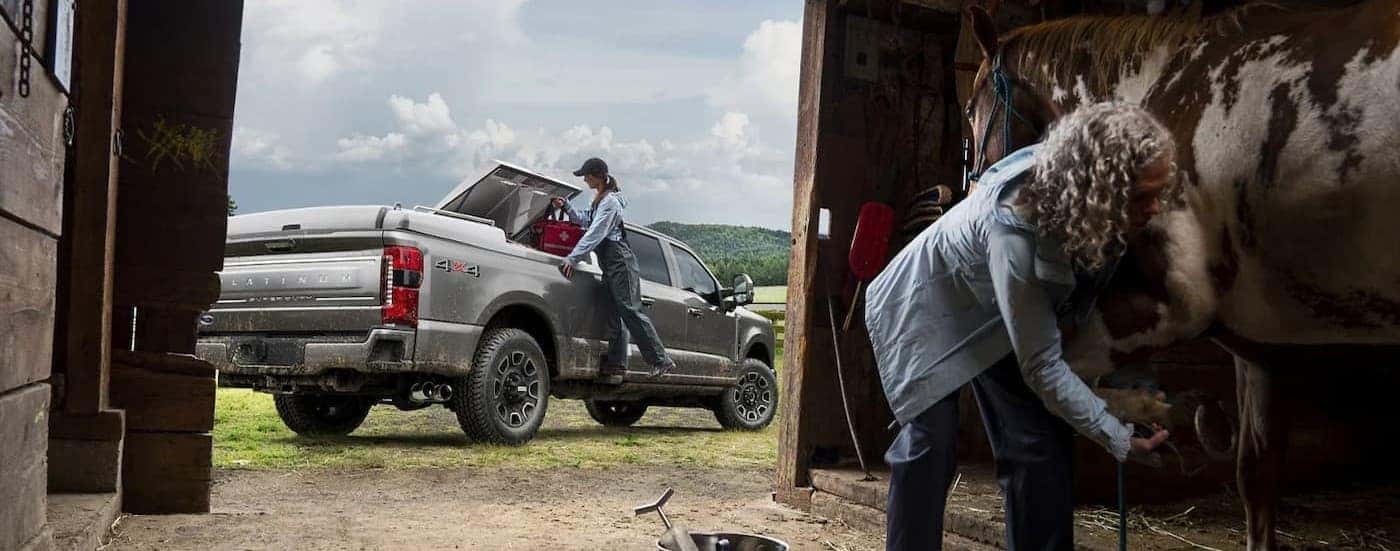 A silver 2025 Ford F-250 Platinum parked near a barn.