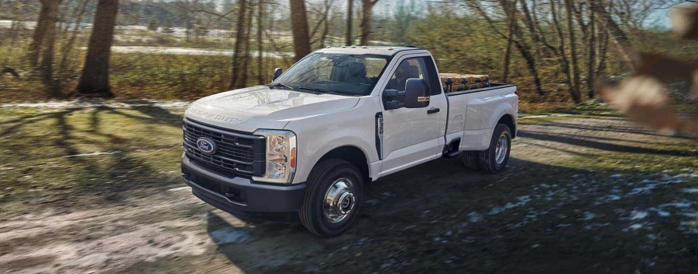 A white 2023 Ford F-350 driving down a trail.