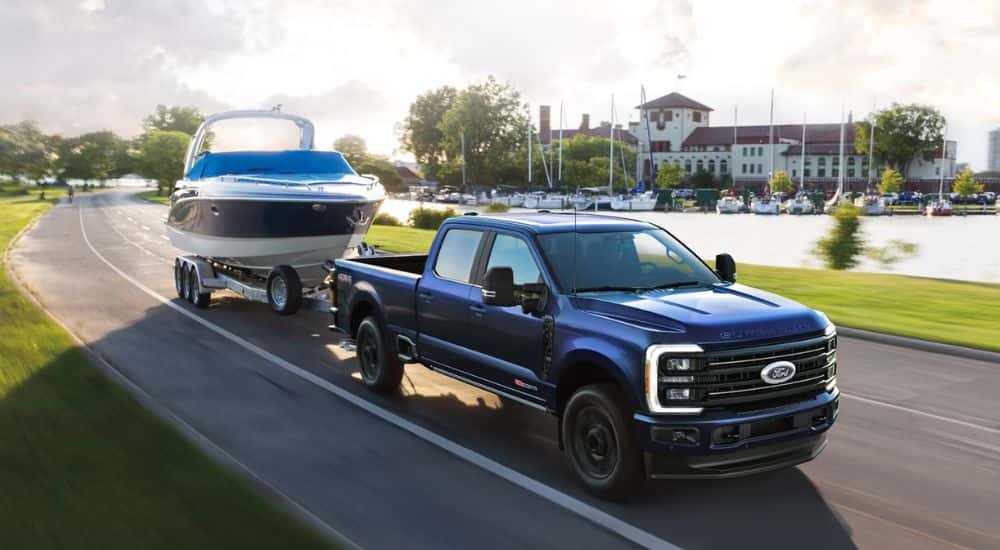 A blue 2026 Ford Super Duty F-350 Platinum towing a speed boat.