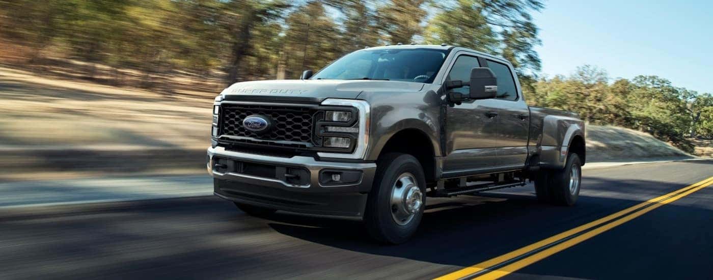 A gray 2026 Ford F-350 XL STX DRW driving a paved road.